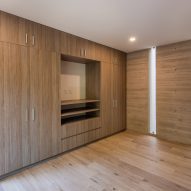 Room with timber flooring and built-in wooden wall storage