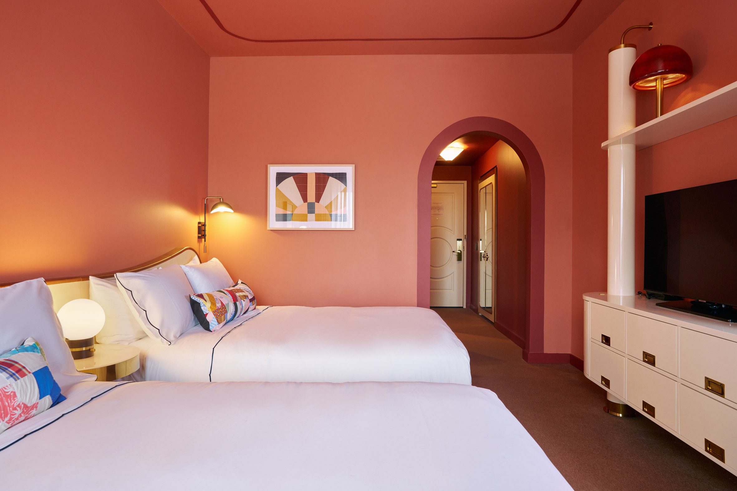 Terracotta-coloured hotel room with two queen beds