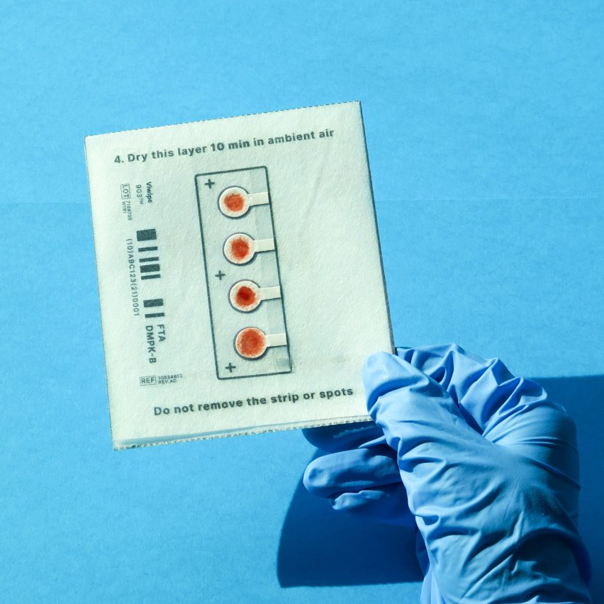 Blue gloved hand holding test sample