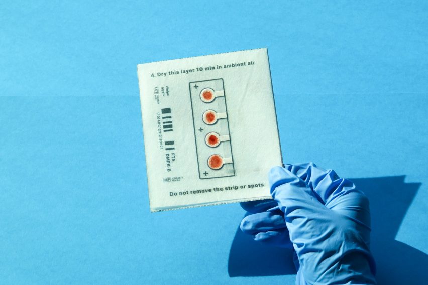 Blue gloved hand holding test sample