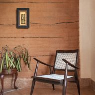 Chair in front of rammed earth wall in Hybrid House by Sketch Design Studio