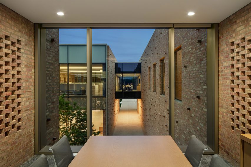 Office meeting room with exposed brick walls and large windows overlooking another building