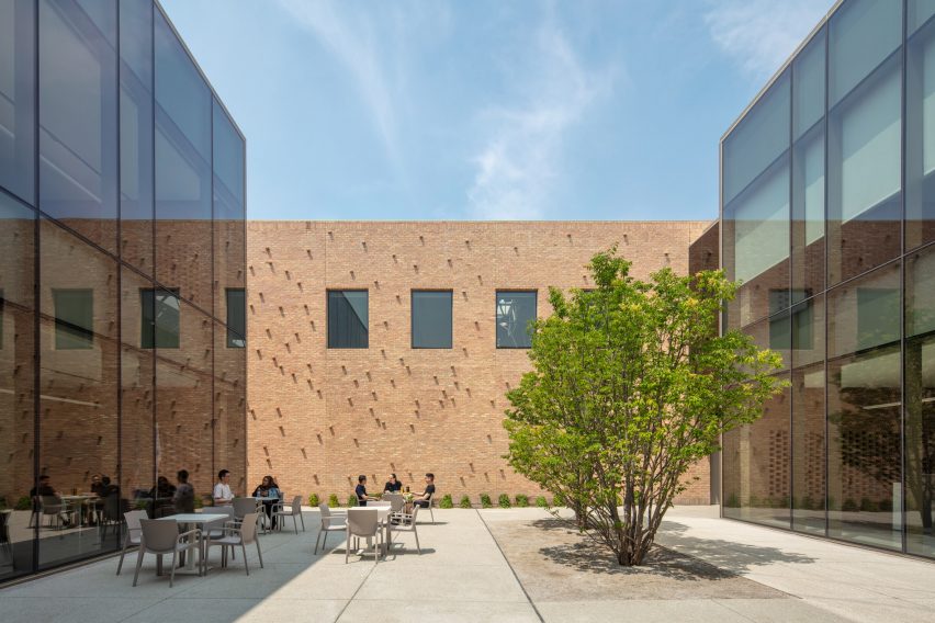 Courtyard surrounded by a two-storey brick and glass buildings by John Ronan Architects