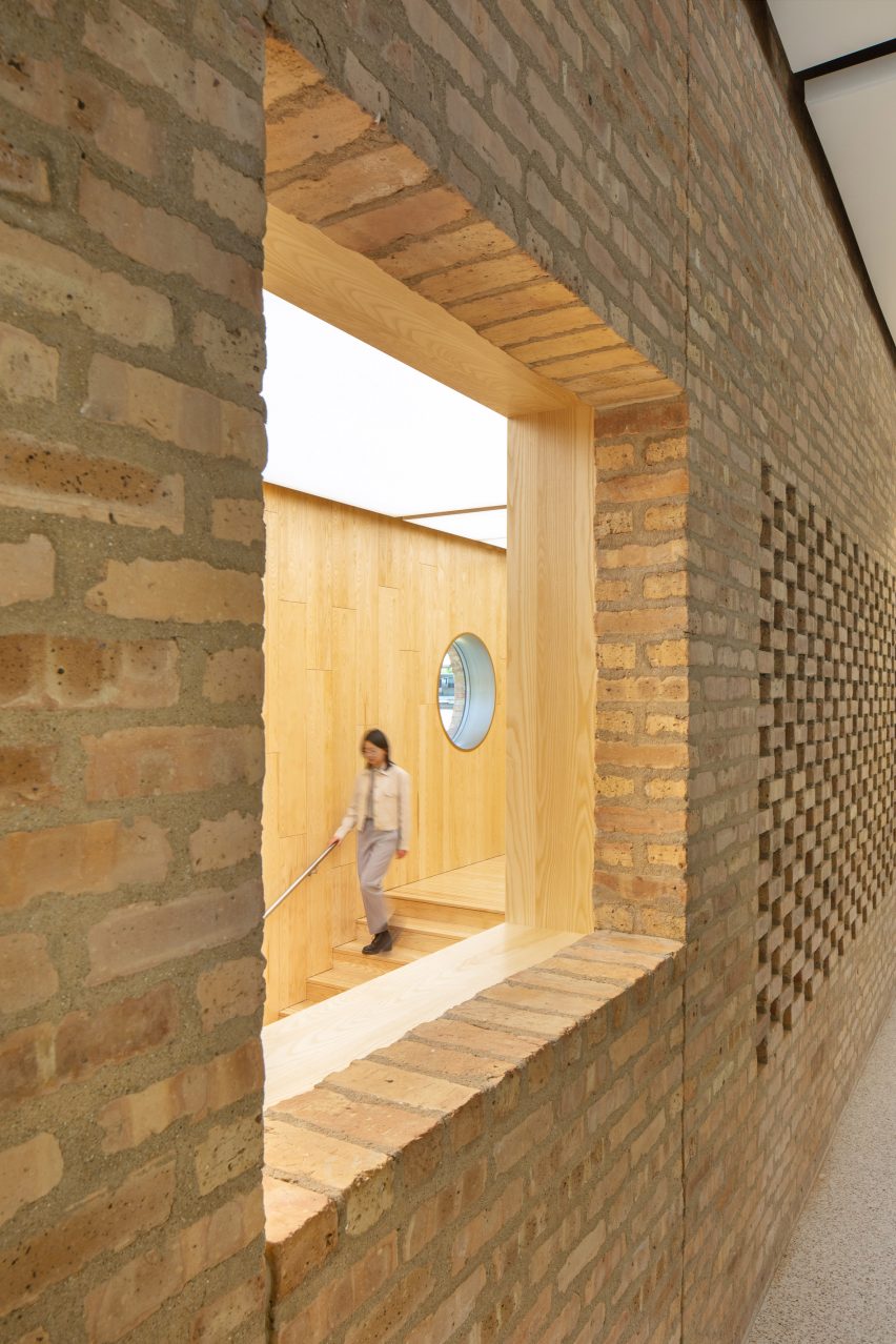Opening in a brick wall revealing a wood-clad interior