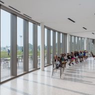 Children sitting in a white interior with a glass facade