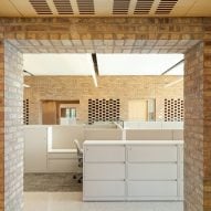 Opening in a brick wall revealing an office space