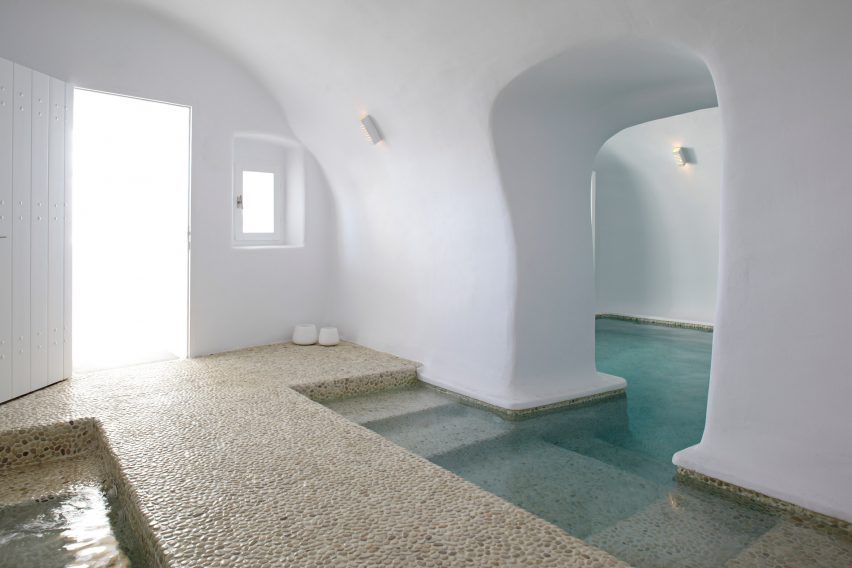 Cave-like white interior with pebble floors and pools