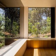 Large windows in a corner of a room that looks out at a forest