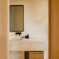 A bathroom with light walls and a mirror with a black frame