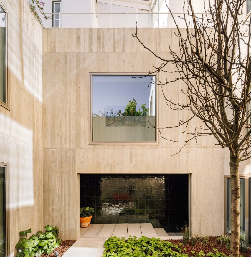 Patio in casa in cemento con loggia in mattoni verdi di Bak Gordon Arquitectos