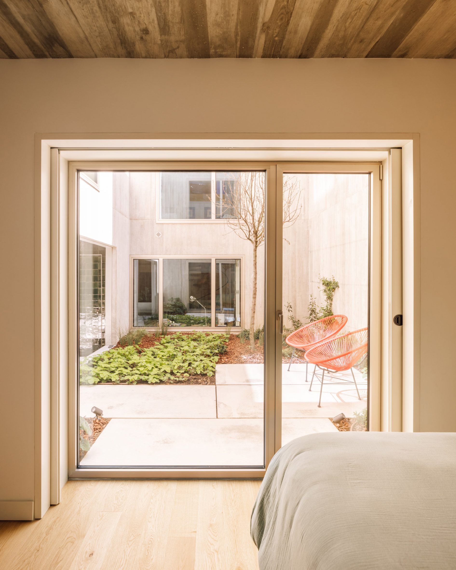 Bedroom with glazed patio doors leading to a courtyard