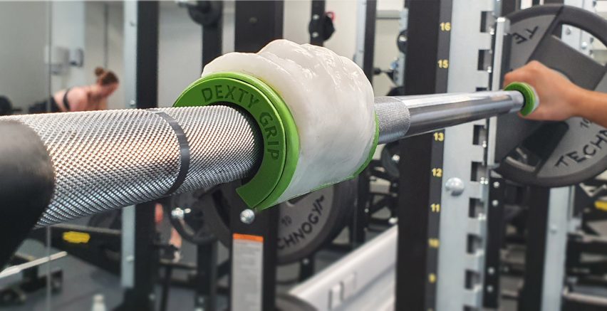 Product that helps individuals with dexterity problems in the gym secured on weightlifting bar