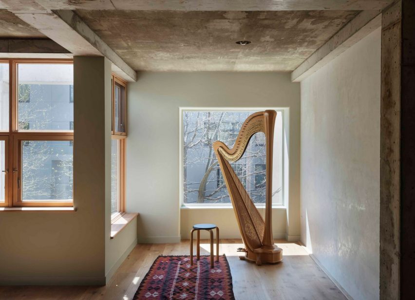 L-shaped bedroom with a harp and a stool