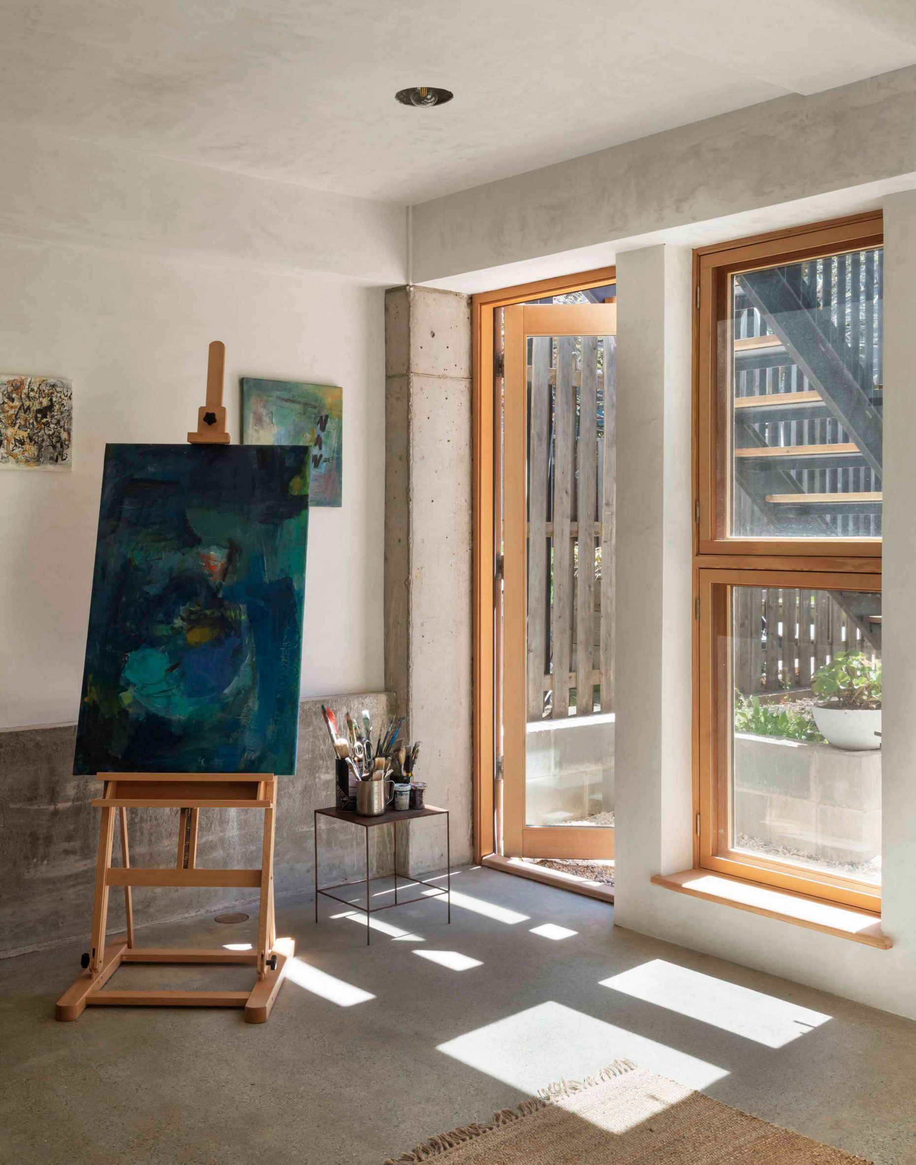 Flexible art studio with concrete flooring and large rectilinear windows