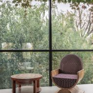 Photograph of wooden chair and table in front of big window