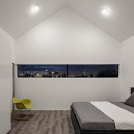 Bedroom with a pitched roof, white walls and narrow window