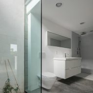 Bathroom with concrete flors, white walls and glass shower door