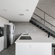White kitchen with an island and mezzanine above