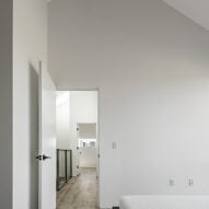 White room with a pitched roof and wood flooring