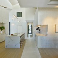 White marble kitchen with wood flooring and a concrete footpath