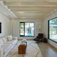 Living room interior with exposed roof beams and white sofa
