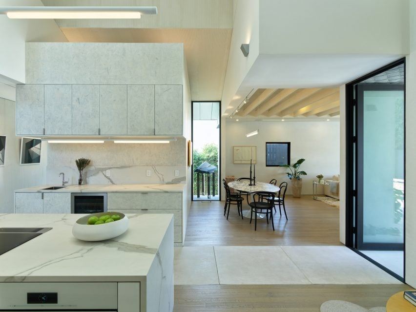 Open-plan interior containing a marble kitchen and dining area