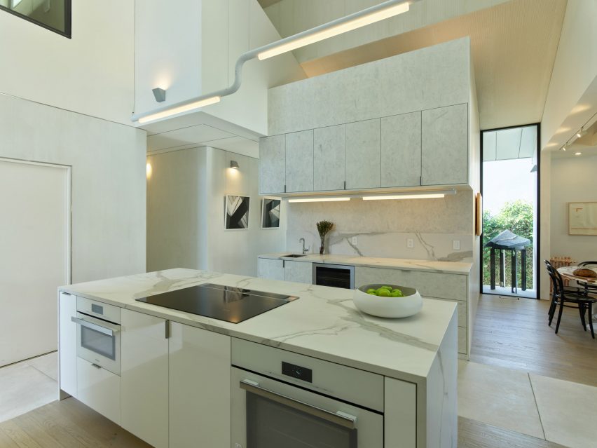 Open-plan interior with a marble kitchen and angular roof