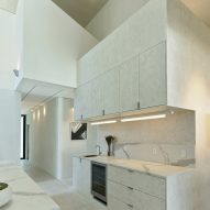 White marble kitchen in a double-height space