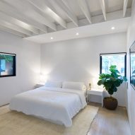 White bedroom with exposed roof beams
