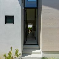 Glass door leading to a corridor at the House 5 bungalow extension by The LADG