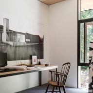 Wooden desk and chair in a white room with concrete floors