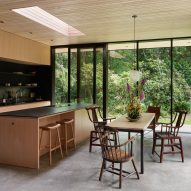 Open-plan kitchen with wooden unit, island and dining table with chairs