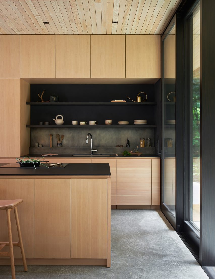 Kitchen with timber units and island topped with black marble