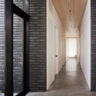 Corridor with white and black brick walls, concrete floors and wood ceiling