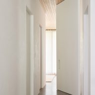Corridor with white walls, wood ceiling and concrete floor