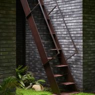 Metal staircase next to a black brick wall