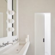 White bathroom with a double sink and timber ceiling