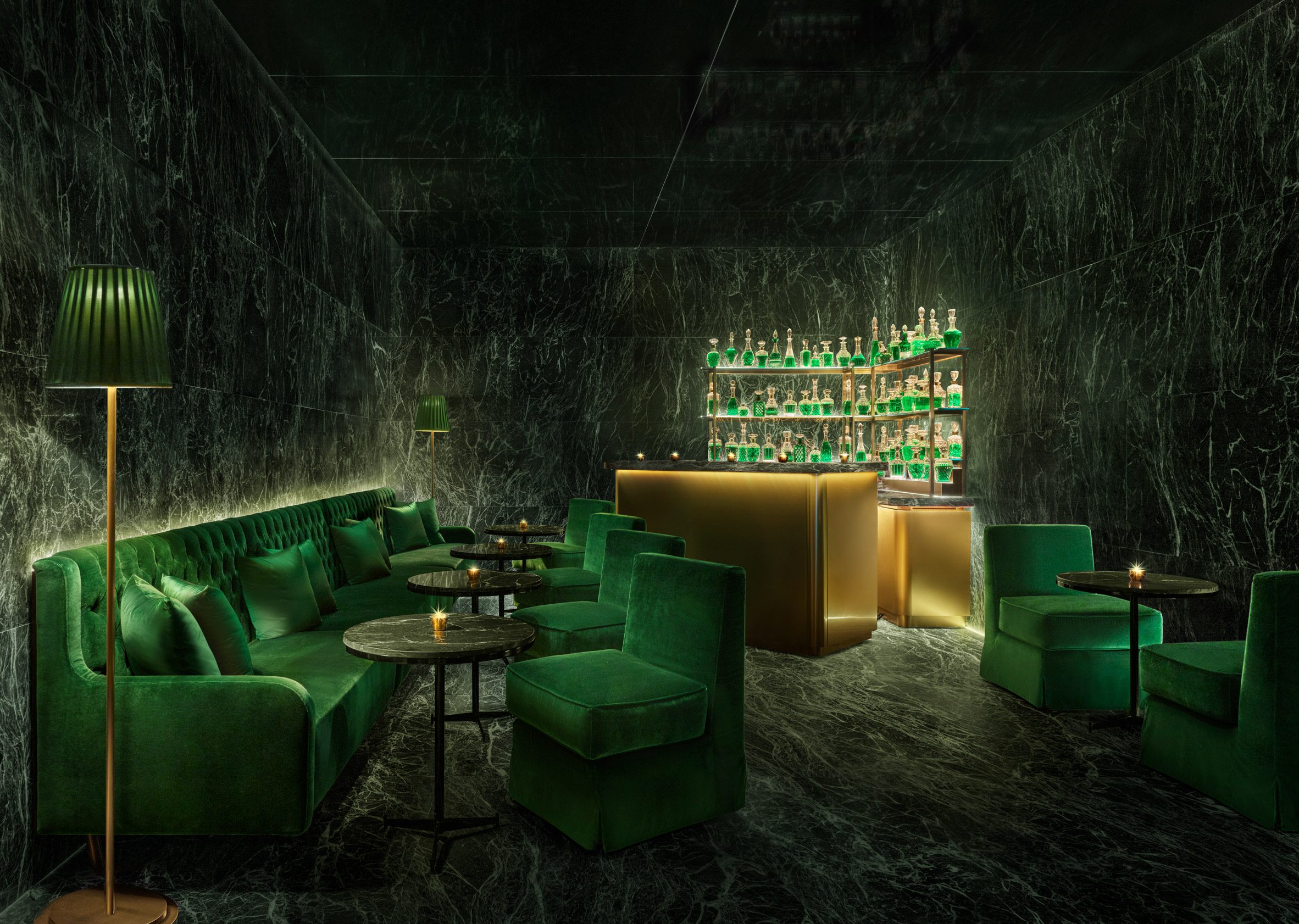 Bar decorated with antique green marble, emerald seating and brass accents