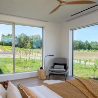 Lounge chair in a bedroom with windows overlooking a field