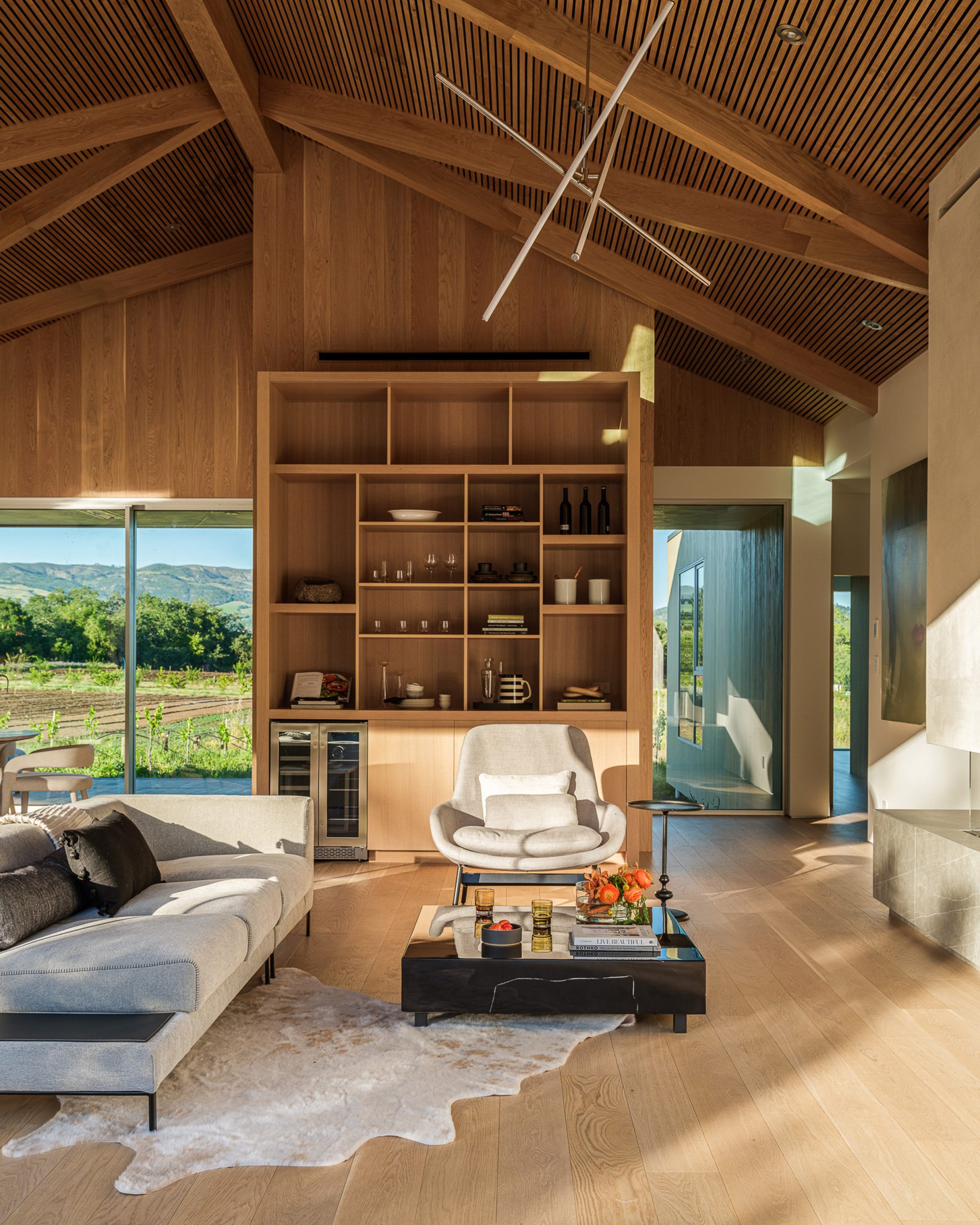 Living room in a timber farmhouse with built-in wooden storage and views of fields