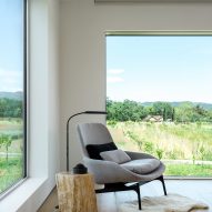 Lounge chair in a room with windows overlooking a field