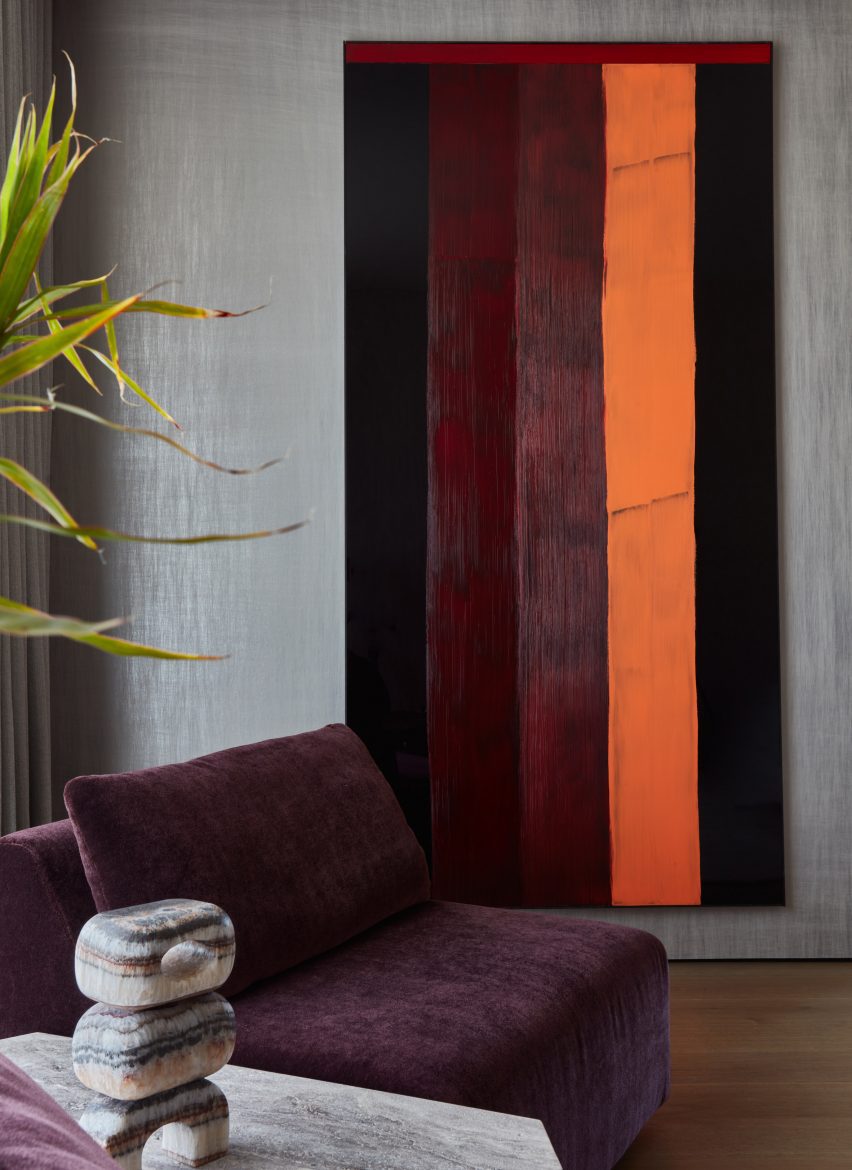 Vertical striped painting behind a burgundy lounge chair