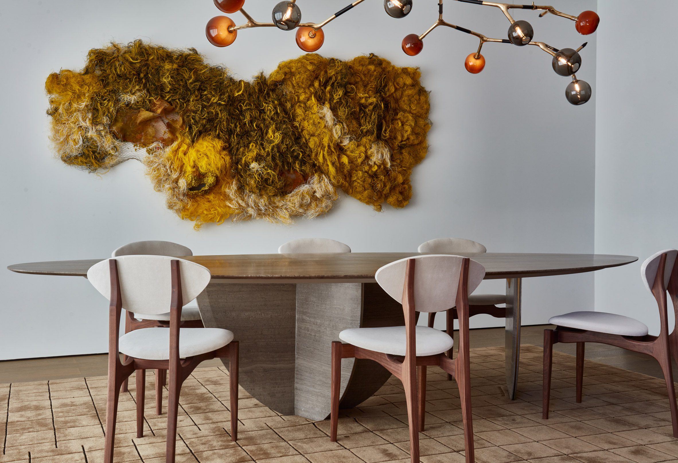 Sculptural dining table, branch-like chandelier and textured wall artwork