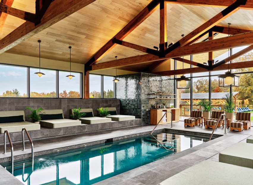 Indoor swimming pool with exposed timber trusses and slate floors
