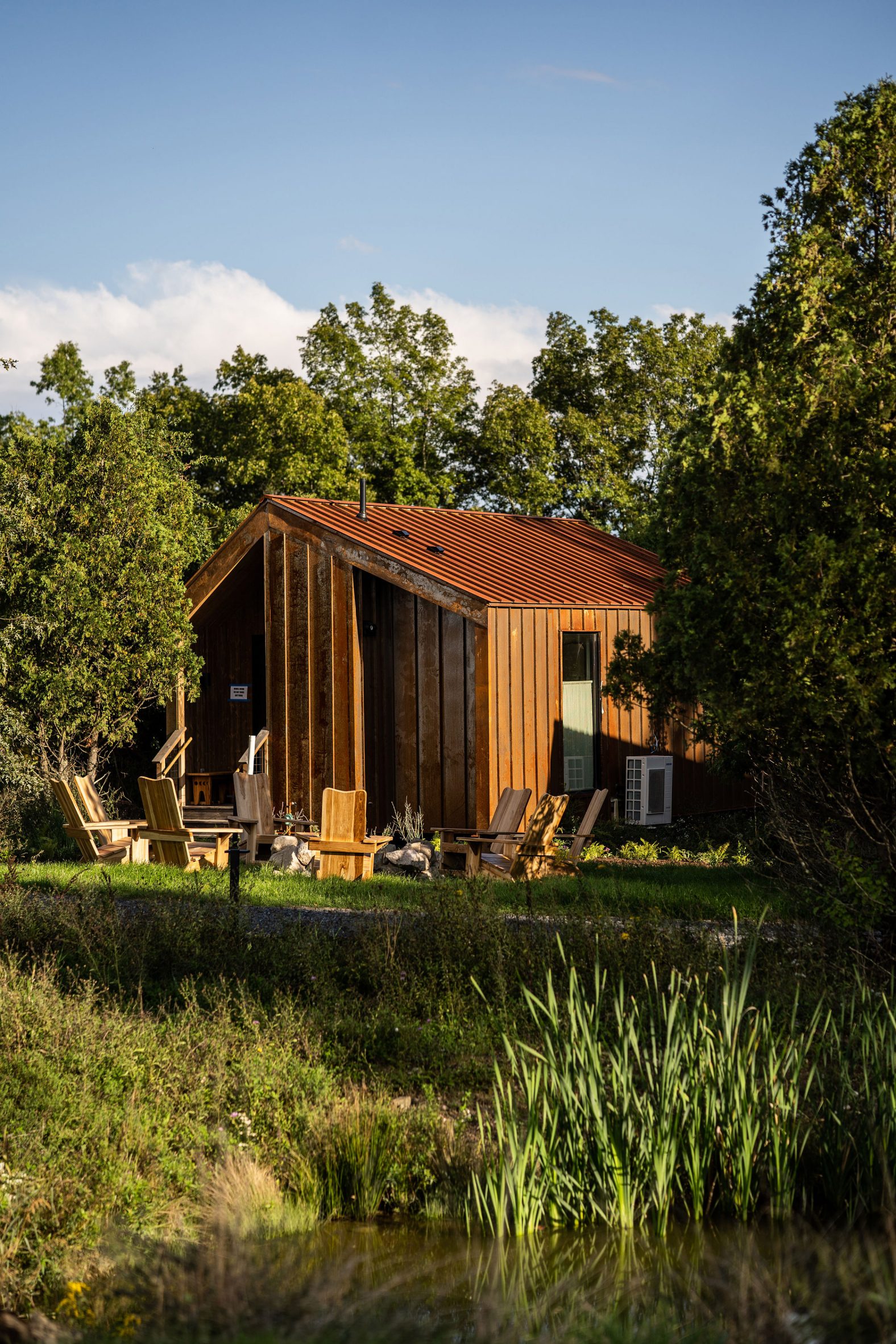 Cabin clad in Corten steel surrounded by trees