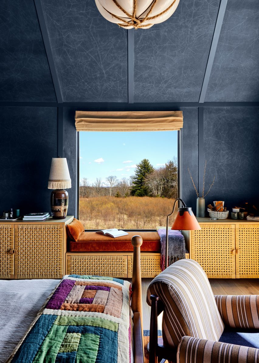 Bedroom interior with dark blue walls, woven cabinet fronts and patterned textiles