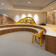 A room with curving benches and a yellow wall