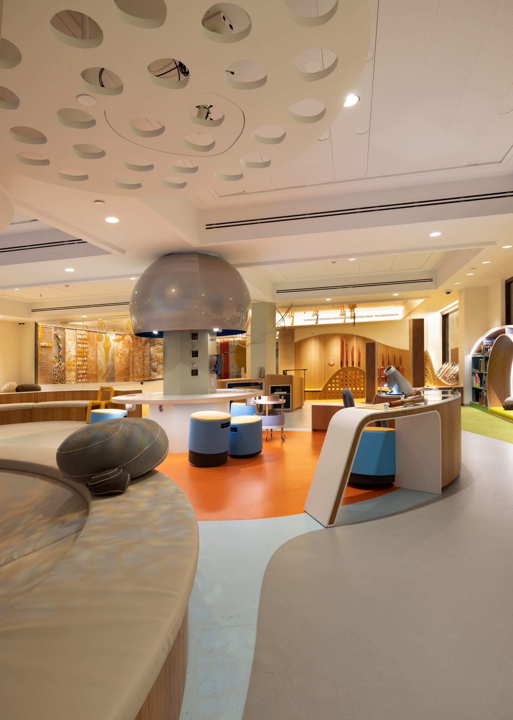 Playroom with layered ceiling and curving benches and stools