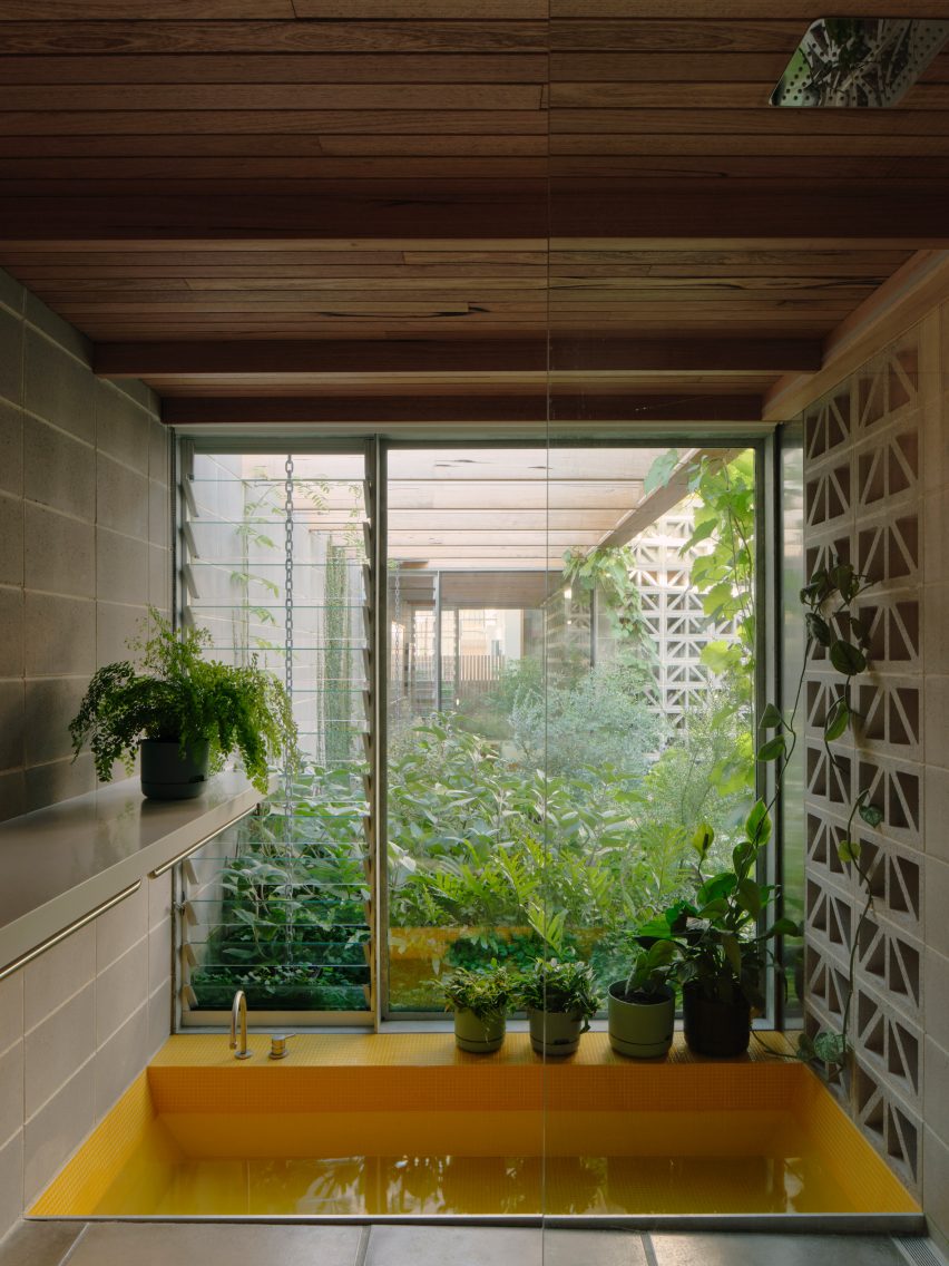 Yellow bath by a window with perforated breeze block walls