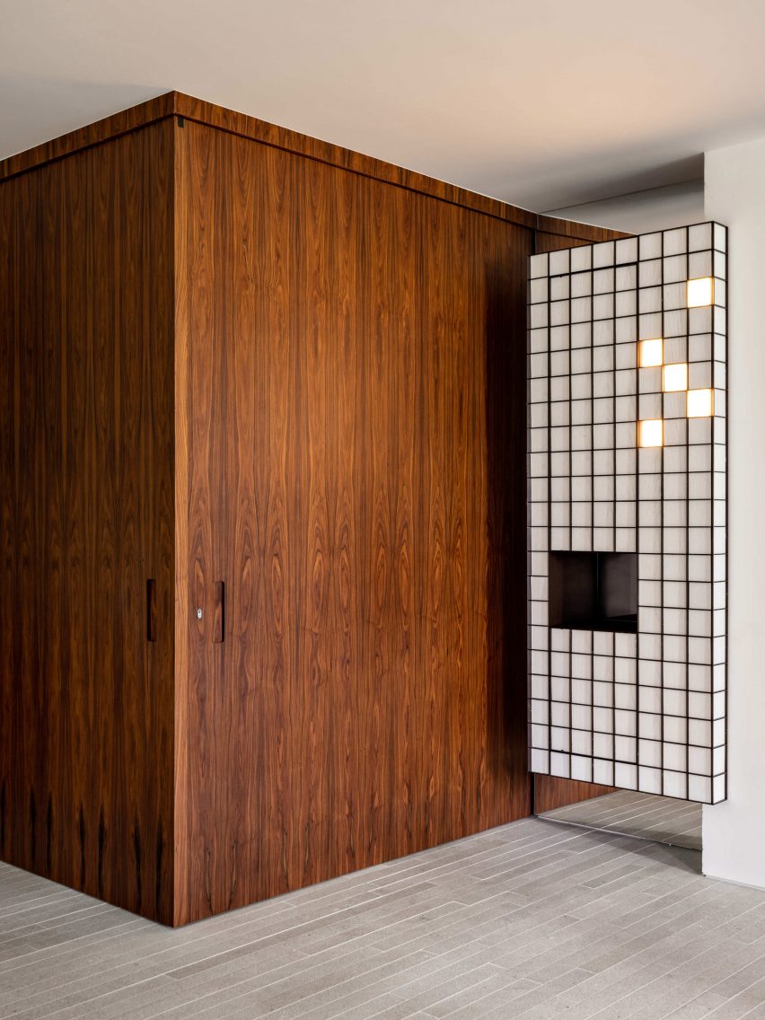 Floor-to-ceiling wood panelling and a gridded cabinet